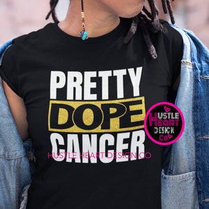 Puede incluir: Una camiseta negra con el texto "Pretty Dope Cancer" en letras doradas. El texto "Hustle Heart Design Co." está impreso en letras más pequeñas debajo del texto principal. Un logotipo rosa y blanco con el texto "Hustle Heart Design Co." está en la esquina superior derecha de la imagen.