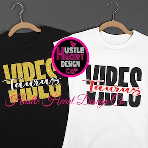 Puede incluir: Dos camisetas, una negra y otra blanca, cuelgan de perchas de madera. La camiseta negra tiene texto con purpurina dorada que dice "Vibes Taurus Girls" con una fuente cursiva rosa debajo. La camiseta blanca tiene texto negro con fuente cursiva roja. El logotipo "Hustle Heart Design Co" es visible.