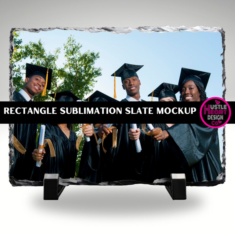 May include: A black slate rectangle with a photo of a group of graduates in black caps and gowns holding diplomas. The slate is on a stand and has a white background.