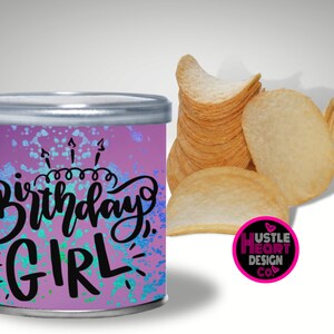 May include: A purple and blue can with a white and black design that says "Birthday Girl". The can is decorated with white and blue glitter. The can is sitting on a white surface.