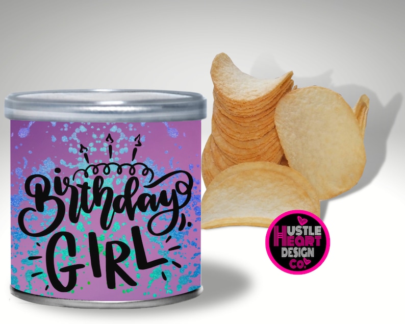 May include: A purple and blue can with a white and black design that says "Birthday Girl". The can is decorated with white and blue glitter. The can is sitting on a white surface.