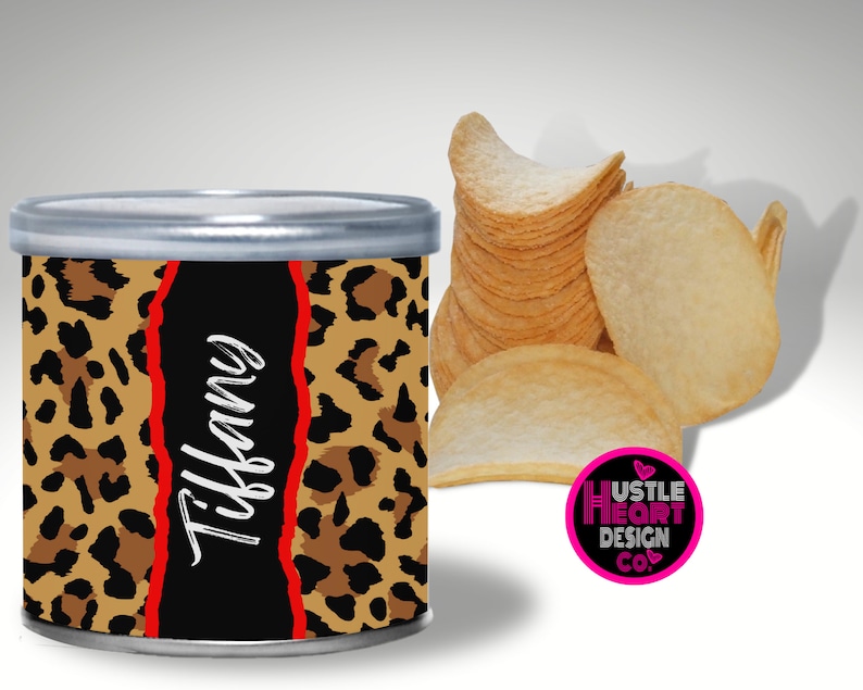 May include: A round metal container with a leopard print design and the name "Tiffany" written in white. The container is filled with potato chips.