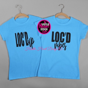 K&ouml;nnte beinhalten: Zwei hellblaue T-Shirts mit schwarzem Text. Das linke T-Shirt sagt "LOC'D Up" mit "Hustle Heart Design Co." in rosa Schrift darunter. Das rechte T-Shirt sagt "LOC'D vibes" mit "Hustle Heart Design Co." in rosa Schrift darunter.