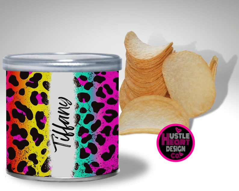 May include: A colorful, personalized chip can with a leopard print design. The can has a white stripe with the name "Tiffany" written on it. The can is sitting on a white surface. The text "Hustle Heart Design Co." is on a pink circle with a heart.
