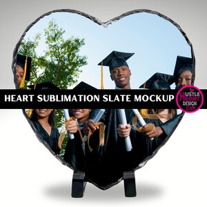 May include: Heart-shaped slate plaque with a sublimation design featuring a group of graduates in black caps and gowns holding diplomas. The slate is on a black stand. The text "HEART SUBLIMATION SLATE MOCKUP" is at the top of the image.