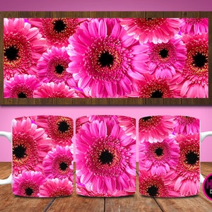 May include: A white ceramic mug with a pink and white floral design. The design features a close-up of pink gerbera daisies.