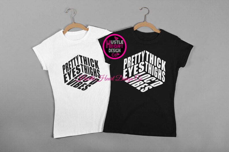 May include: Two t-shirts, one white and one black, with the text "Pretty Thick Eyes Thighs Good Vibes" printed in a 3D-style design.