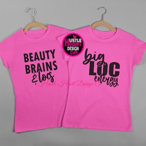 K&ouml;nnte beinhalten: Zwei rosa T-Shirts mit schwarzem Text. Das linke Shirt sagt "Beauty Brains & Locs" mit dem Text "Hustle Heart Design Co." darunter. Das rechte Shirt sagt "Big Loc Energy" mit dem Text "Hustle Heart Design Co." darunter.