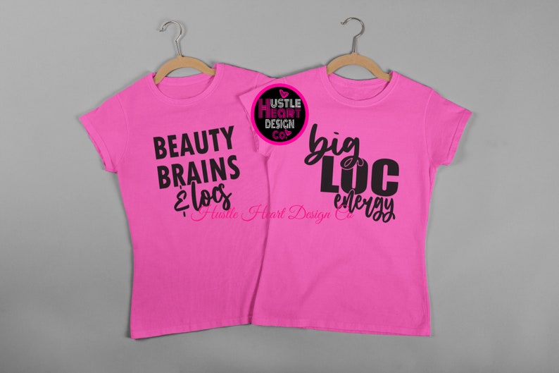 K&ouml;nnte beinhalten: Zwei rosa T-Shirts mit schwarzem Text. Das linke Shirt sagt "Beauty Brains & Locs" mit dem Text "Hustle Heart Design Co." darunter. Das rechte Shirt sagt "Big Loc Energy" mit dem Text "Hustle Heart Design Co." darunter.