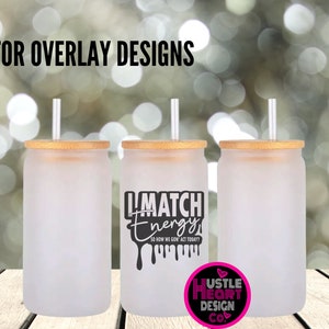 May include: Three frosted glass tumblers with bamboo lids and clear straws. The tumbler on the right has a black graphic that says "I Match Energy" with dripping black paint. The graphic also says "So How We Gon Act Today?" in smaller text. The bottom of the tumbler has a pink heart with the text "Hustle Heart Design Co."
