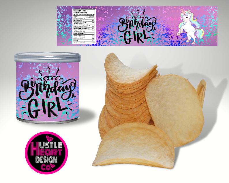 May include: A pink and blue can with a unicorn and the text "Birthday Girl" on it. The can is sitting on a white surface next to a stack of potato chips.