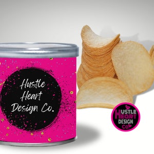 May include: A pink can with a black circle and white text that reads "Hustle Heart Design Co." The can has a gold glitter pattern. The can is sitting on a white surface.