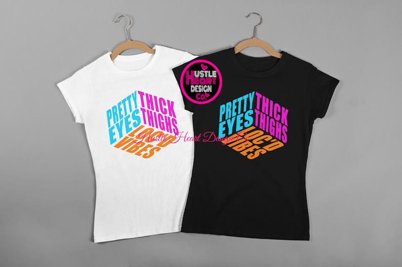 May include: Two t-shirts with the text "Pretty Eyes Thick Thighs Loc'd Vibes" in a colorful, 3D-style design. The shirts are white and black.