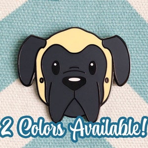 May include: A black and yellow enamel pin of a cartoon English Mastiff dog with big eyes. The pin is on a blue and white chevron patterned background. 2 Colors Available!
