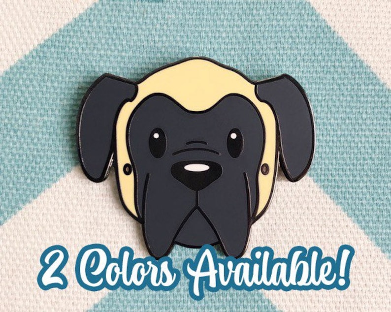 May include: A black and yellow enamel pin of a cartoon English Mastiff dog with big eyes. The pin is on a blue and white chevron patterned background. 2 Colors Available!