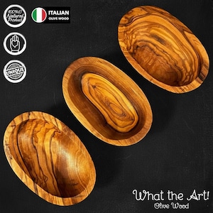 Könnte beinhalten: Drei ovale Olivenholzschalen mit einzigartigen Maserungsmustern. Die Schalen haben eine warme braune Farbe und sind auf einer schwarzen Oberfläche angeordnet. Das Bild enthält den Text "What the Art! Olive Wood".