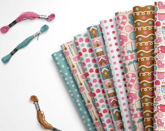 May include: A set of eight different patterned fabric squares featuring gingerbread houses, candy canes, and other winter holiday motifs. The fabric squares are arranged in a fan shape and are surrounded by spools of embroidery floss.