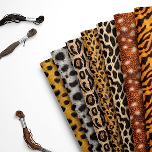 May include: An assortment of animal print fabrics in various patterns, including leopard, zebra, and tiger stripes. Three spools of embroidery floss in black, brown, and tan are also present.