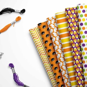 May include: A set of eight Halloween-themed fabric scraps with various patterns, including ghosts, spiders, candy corn, and polka dots. The fabric scraps are arranged in a fan shape and are accompanied by three spools of embroidery floss in black, orange, and purple.