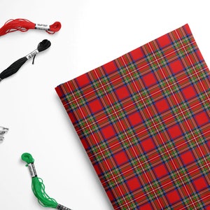 May include: Red, green, and blue plaid fabric with three spools of embroidery floss in red, black, and green.