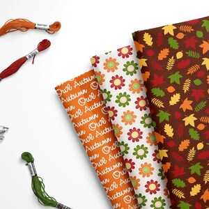 May include: Three fabric patterns featuring autumn themes. The first pattern is orange with the text "Owl Autumn" repeated. The second pattern is white with red, yellow, and green flowers. The third pattern is brown with red, orange, yellow, and green leaves.