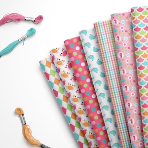 May include: A collection of ten fabric swatches featuring various sea-themed patterns. The patterns include crabs, whales, seashells, and starfish. The fabrics are in shades of pink, blue, green, and orange.