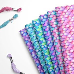 May include: A set of six iridescent mermaid scale fabric sheets in shades of pink, blue, and green. The fabric sheets are arranged in a fan shape and are perfect for crafting projects.