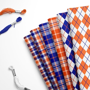 May include: A collection of five folded fabric pieces featuring orange and blue patterns, including argyle, plaid, and checkered designs, accompanied by three individual skeins of embroidery floss in orange, blue, and white colors.