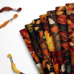 May include: An assortment of autumn-themed craft supplies. The image features several sheets of patterned paper with leaf and floral designs in shades of orange, brown, and gold. Also included are three spools of embroidery floss in coordinating colors.
