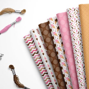 May include: A collection of eight fabric squares with different ice cream themed patterns. The patterns include ice cream cones, sprinkles, and waffle cones. The fabrics are in shades of pink, brown, and white.