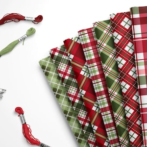 May include: A stack of red and green plaid fabric with red and green embroidery floss and safety pins.