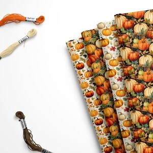 May include: Four rolls of wrapping paper with a pumpkin pattern. The paper is white with orange and brown pumpkins, and one roll is black with orange and white pumpkins.