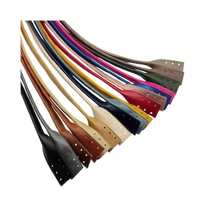 Op de afbeelding: Een assortiment lederen riemen in verschillende kleuren, waaronder bruin, zwart, blauw, rood en geel. De riemen zijn allemaal even lang en breed en hebben een decoratief stikselpatroon.