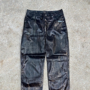 May include: Black leather pants with a snakeskin pattern and gold accents.