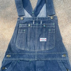 Könnte beinhalten: Dunkelblaue Jeans-Latzhosen mit einem