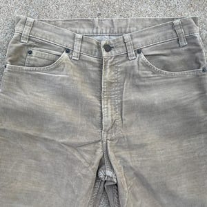 May include: A pair of light brown corduroy pants. The pants have a straight leg and a classic five-pocket design.