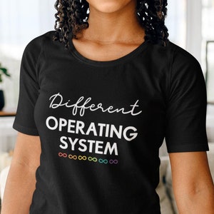 Może przedstawiać: Czarny T-shirt z białym tekstem, kt&oacute;ry brzmi "Different Operating System" z tęczą symboli nieskończoności pod tekstem.