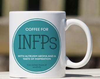 May include: White ceramic coffee mug with a teal circle design that says "COFFEE FOR INFPS WITH ALTRUISM AROMA AND A TASTE OF INSPIRATION. Can contain traces of sensitivity."