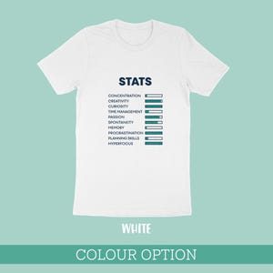 May include: A white short-sleeved t-shirt featuring a dark blue graphic titled STATS. The design displays a list of attributes including concentration, creativity, curiosity, time management, passion, spontaneity, memory, procrastination, planning skills, and hyperfocus, each paired with a horizontal progress bar.