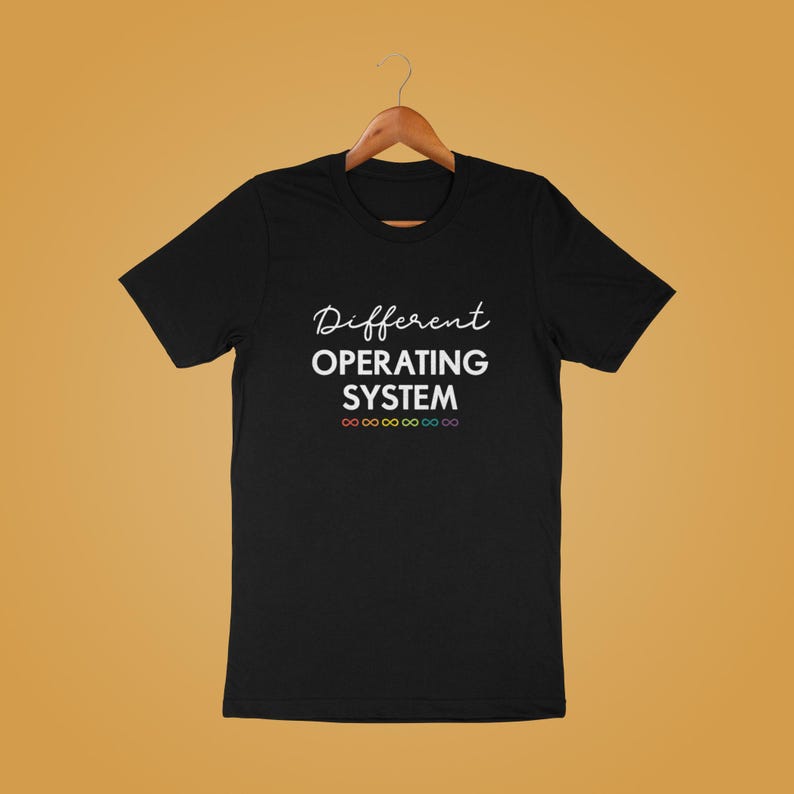 Może przedstawiać: Czarny T-shirt z białym tekstem, kt&oacute;ry brzmi "Different Operating System" i rzędem tęczowych symboli nieskończoności pod tekstem.
