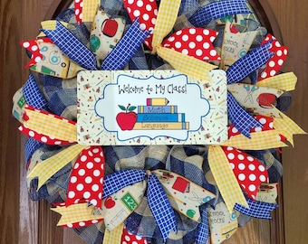May include: A blue, yellow, and red school-themed wreath with a sign that reads "Welcome to My Class!" with a stack of books that say "Math, Science, Language".