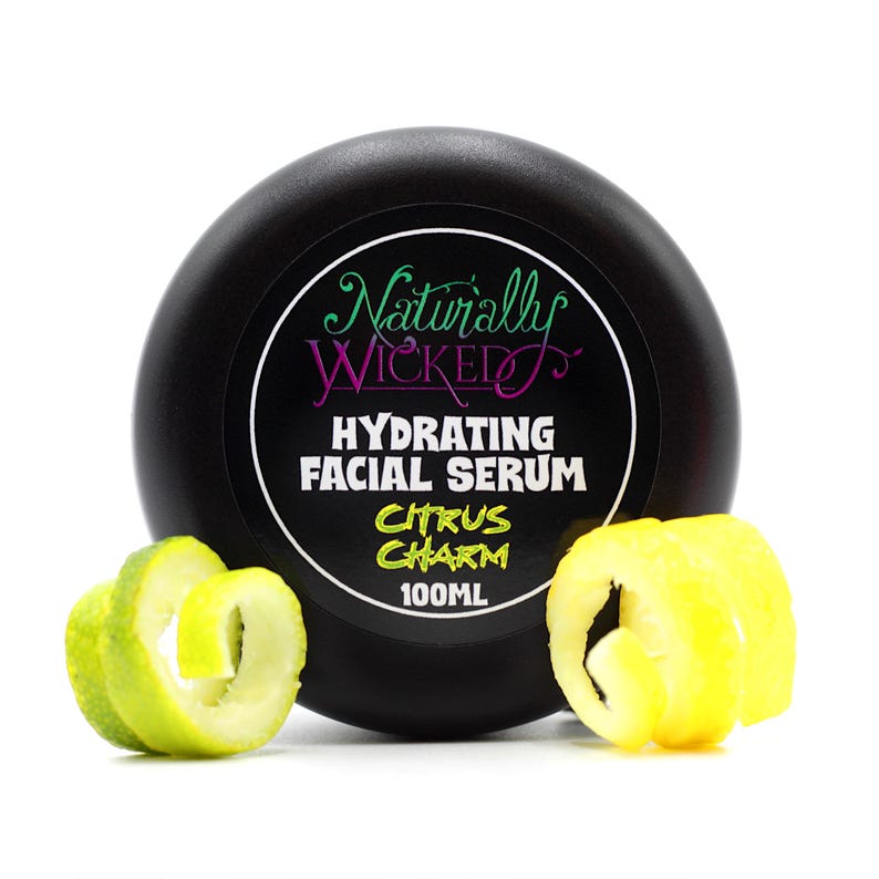 Naturally Wicked Citrus Charm Hydrating Facial Serum in sleek black jar, styled with lemon and lime twists.