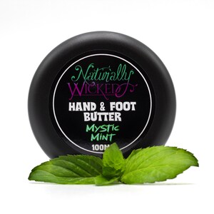 Naturally Wicked Mystic Mint Hand & Foot Butter Classy Black Lid Amongst Bright Green Fresh Mint Leaves