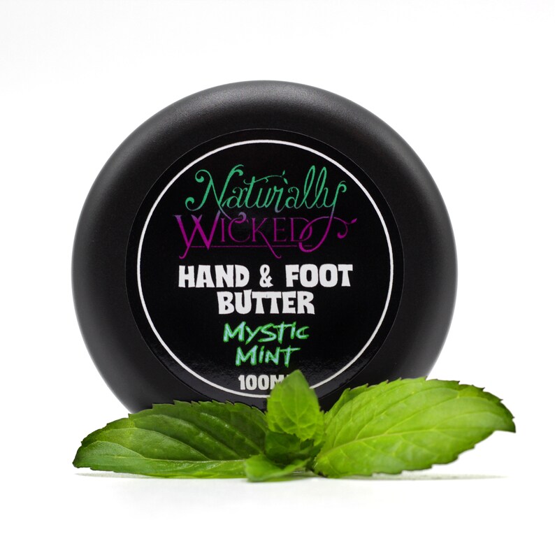 Naturally Wicked Mystic Mint Hand & Foot Butter Classy Black Lid Amongst Bright Green Fresh Mint Leaves