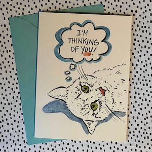 Tarjeta de felicitación pintada a mano con la frase "Pensando en ti". Los dueños o amantes de las mascotas pueden enviar cálidos saludos con esta tarjeta ilustrada con un tierno gatito.