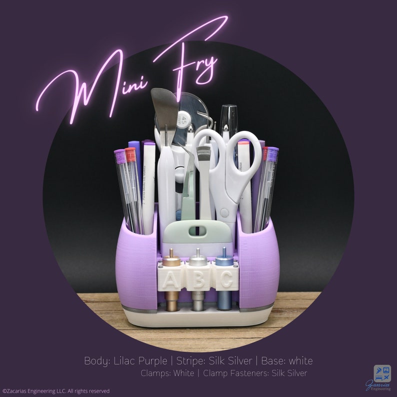 May include: A lilac purple desk organizer with various craft tools, including scissors, pens, and a spatula. The organizer has a white base and silver accents, with the text "Mini Fry" in a cursive font.