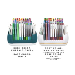 May include: Two pen holders filled with colourful pens and markers. One holder is emerald green with a white base, the other is white with a gold stripe and white base. The image text says "Cricut infusible ink".