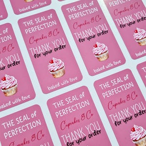 May include: Pink and white cupcake stickers with the text "The Seal of Perfection Cupcakes & Co. Thank You for your order" and "baked with love".