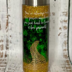 May include: A gold and green glitter tumbler with a yellow brick road design and the quote "You've always had the power my dear you just had to learn it for yourself".