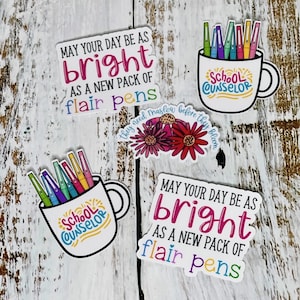 May include: Four colorful stickers with the text "May your day be as bright as a new pack of flair pens" and "School Counselor" with a mug and colorful pens inside. One sticker has a floral design with the text "They need Maslow before they bloom."